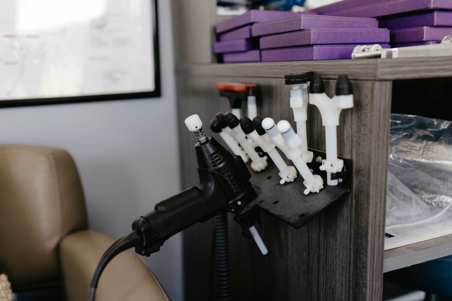 A close-up of a hand tool percussion device being used in exercise rehabilitation therapy to aid muscle recovery.