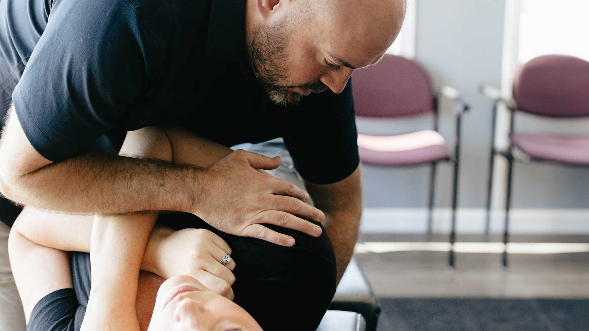 Dr. Dylan Miller performing a spinal adjustment on a patient lying on a chiropractic table to relieve pain and improve alignment.