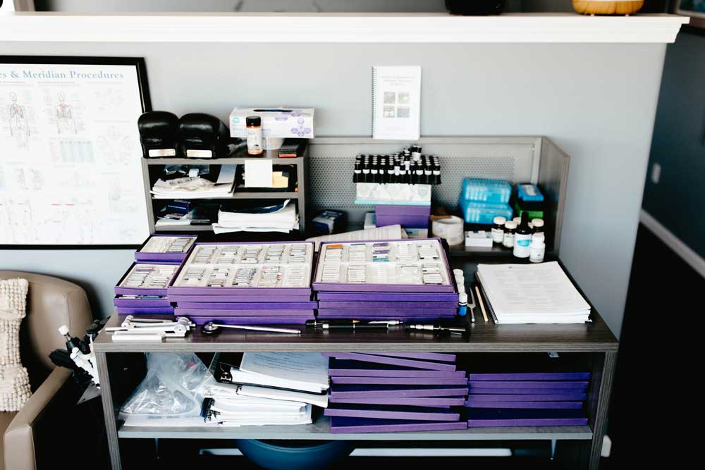 Various assessment tools and testing kits used for Applied Kinesiology (AK) evaluation, displayed on a table.