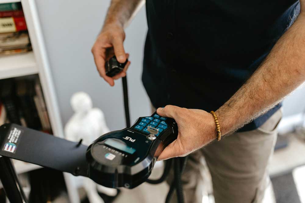 Dr. Miller applying a PLS laser therapy device to a patient for pain relief and healing.